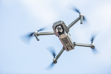 Close-up quadcopter drone with camera flying in park