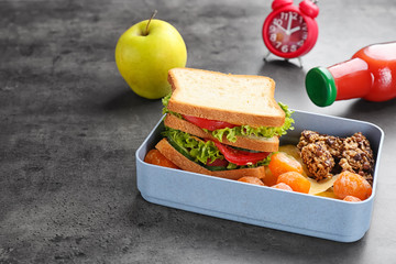 Lunch box with appetizing food on grey background
