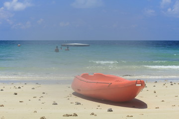 red kayak on the white sand beach