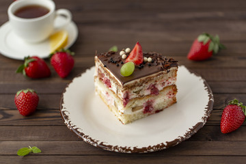 Delicious cake with strawberries, grapes, chocolate, tea with lemon