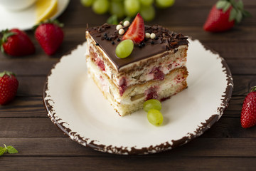 Delicious cake with strawberries, grapes, chocolate