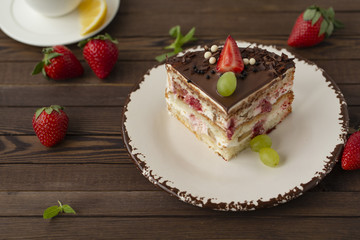 Delicious cake with strawberries, grapes, chocolate, tea with lemon