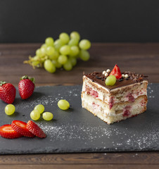 Delicious cake with strawberries, grapes, chocolate