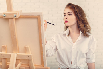 Beautiful young woman painter at work