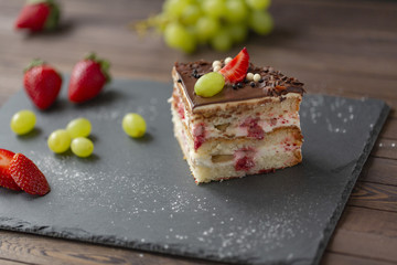 Delicious cake with strawberries, grapes, chocolate