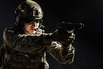 Special forces soldier with rifle on dark background