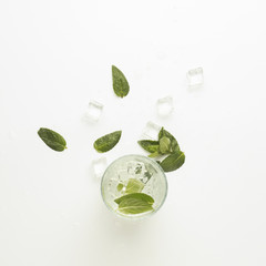 Obraz premium Glass with a refreshing drink with mint and ice on a light background. Flat lay, top view
