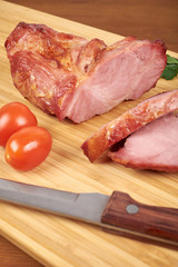 Cooked sliced pork barbecue steak on wooden cutting board.