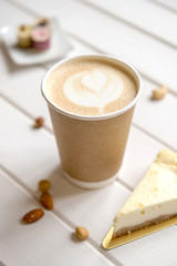 Cup of coffee on wood background with snacks