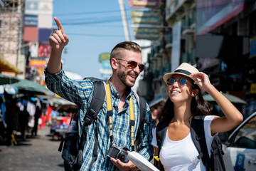 Interracial tourist backpacker couple traveling in Bangkok Thailand
