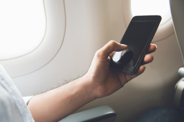 Male passenger turning off mobile phone on the airplane