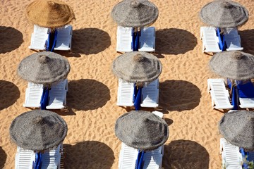 Sun loungers and parasols on the beach seen from above, Albufeira, Portugal.