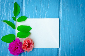 beautiful flower and white paper on blue background,top view ,break time,empty space.