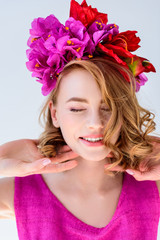Naklejka premium beautiful happy woman with flowers in hair smiling with closed eyes isolated on grey