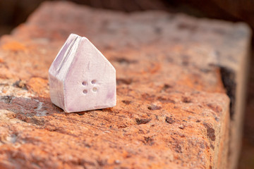 Miniature toy house stands on a stone surface