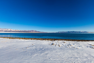   The frozen Sailimu lake with snow mountain background at Yili, Xinjiang of China