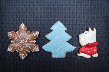 Beautiful Christmas gingerbread honey cookie in shape of snowflake, New Year tree and dog.