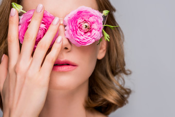 Fototapeta na wymiar close-up view of girl adjusting eyeglasses with flowers isolated on grey
