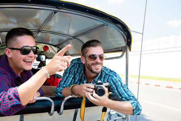 Tourists being excited and having fun on Tuk Tuk taxi in Thailand