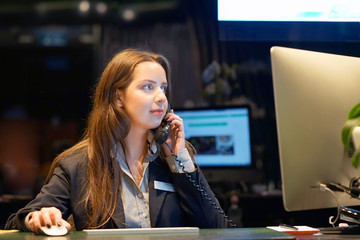 Hotel administrator. A woman-reception worker accepts an order for booking a room by phone. Profile shot of attractive executives at the reception of a hotel. The concept of service.
