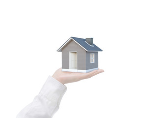 Simple house in human hand isolated on white background with clipping path. Image idea of real estate and property concept. House 3D render.