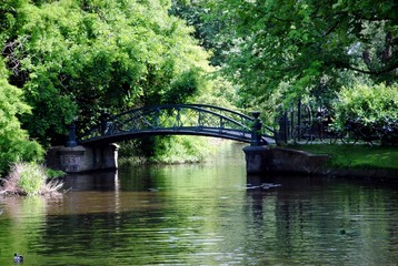 Fototapeta na wymiar Green cast iron footbridge near Botanical Garden, Amsterdam