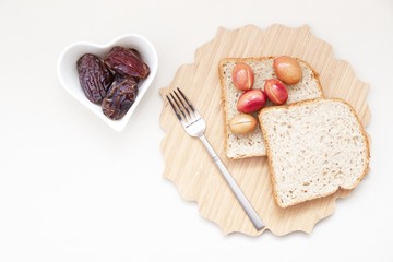 Ramadan Kareem celebration with islamic date, olive, glass of water, bread foods on white background