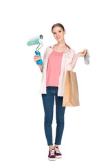 young woman with paint rollers, shopping bag and protective gloves isolated on white background