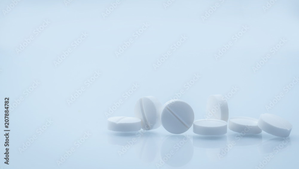 Wall mural 7 white round tablets pill isolated on white background with beautiful and unique pattern with copy 