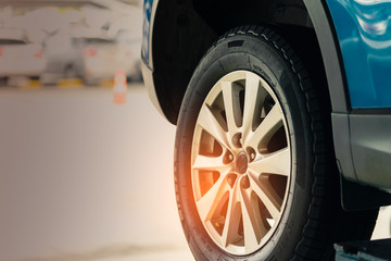Selective focus on blue SUV car rear wheel on blurred background. Car with new high performance...