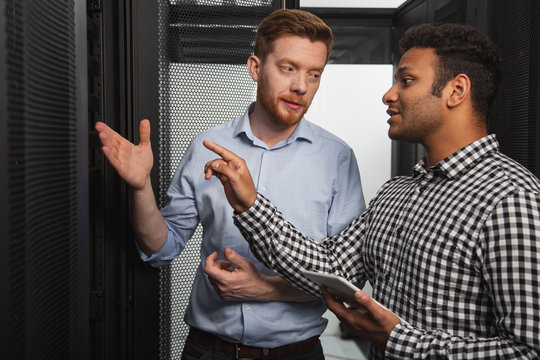 IT problem. Professional IT technicians talking and pointing at hardware - Powered by Adobe