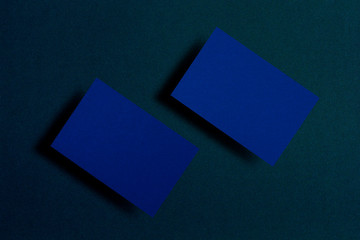 Mock up of two horizontal blue business cards at dark blue textured paper background. Mock-up template for branding identity. For graphic designers presentations and portfolios