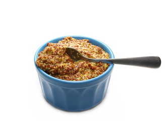 French mustard sauce in blue porcelain bowl with metal spoon isolated on white background and texture