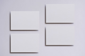 Photo of blank white business cards on white. Mock-up for branding identity. For graphic designers presentations and portfolios