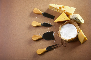 Assortment of cheese with Cheese Serving Knife. Camembert or brie cheese circle, top view image with copy space, set