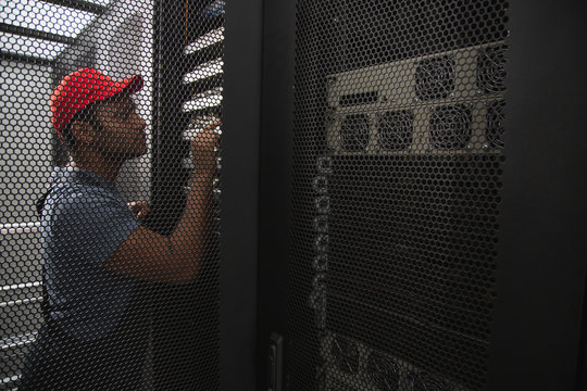 Crucial Worker. Smart IT Engineer Rising Hand While Studying Server Closet