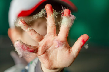The boy's hand is soiled in colorful cotton candy. Closeup, selective focus