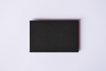 Mockup of blank textured black business card at white background