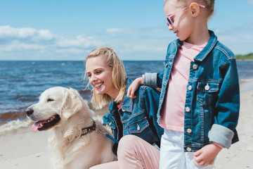 beautiful family with golden retriever dog near water