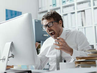 Angry business executive shouting at the computer