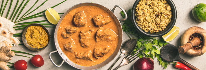 Traditional curry and ingredients on concrete background