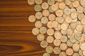 Stack of coin on wooden working table, business and finance concept.