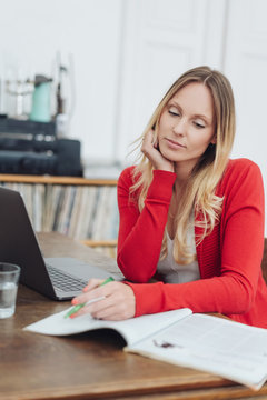 Young woman sitting working or studying at home