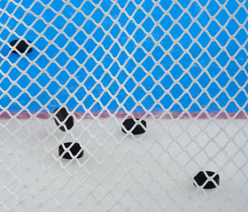 Closeup view of nylon netting. Color patterns in the background, these are logos on hockey ice. The netting is to prevent the puck from hitting the hockey fans.