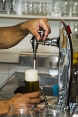 Bartender pouring fresh cold beer from tap
