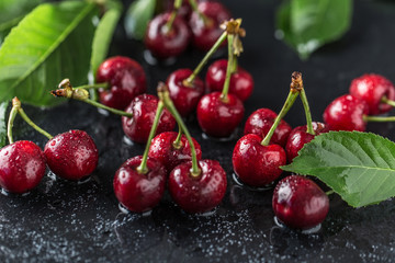 Fresh cherry with water drops on dark stone background. Fresh cherries background. Healthy food concept