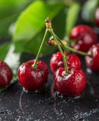 Fresh cherry with water drops on dark stone background. Fresh cherries background. Healthy food concept
