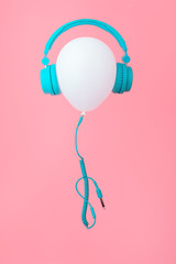 White balloon with tiffany color headphones on Pink background. Contemporary design. Trendy colors. Vertical