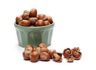 Hazelnuts in green porcelain bowl isolated on white background