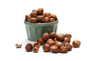 Hazelnuts in green porcelain bowl isolated on white background